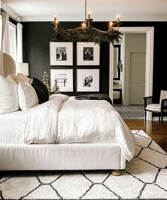 a bedroom with black walls and white bedding