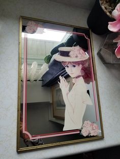 a mirror with a woman in a pink hat and flowers on the side next to it