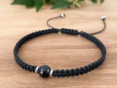 a black beaded bracelet on a wooden table