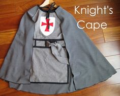 the knight's cape is made from gray and black fabric with a red cross on it