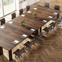 a large conference table with chairs and laptops on it in the middle of a room