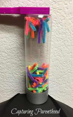 a glass filled with lots of colorful confetti sitting on top of a table