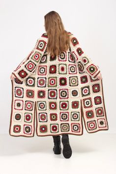 a woman wearing a crocheted granny granny afghan shawl with circles on it