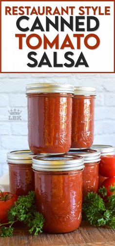 four jars filled with tomato sauce sitting on top of a wooden table