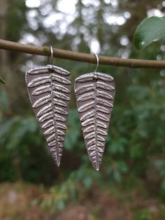 ❧Handmade Silver Fern Earrings  ❧Each pair is made to order and will take up to 8 weeks to ship out ❧Crafted by hand using .999 fine silver metal clay. More information on this material can be found at http://www.artclay.co.jp/htm/about/ ❧Ear Wires are made of rhodium plated .925 sterling silver ❧I make all my own molds and textures- molds used for this piece are taken from real ferns. ❧The finished piece is oxidized for a darkened effect. Metal Clay Earrings, Hand Cast Silver Dangle Earrings, Silver Hand Cast Dangle Earrings, Handmade Silver Nature-inspired Earrings, Handmade Nature-inspired Silver Earrings, Hand Cast Sterling Silver Drop Earrings, Hand Cast Sterling Silver Earrings, Handmade Sterling Silver Nature-inspired Earrings, Fern Earrings