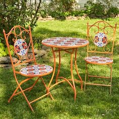 three chairs and a table in the grass