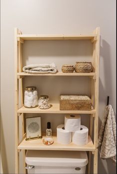 a bathroom shelf filled with toilet paper and other items