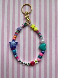 a close up of a beaded bracelet on a pink and white striped background with stars