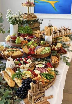 a table filled with lots of different types of food on top of wooden trays