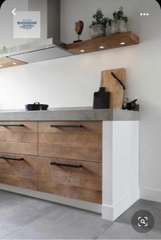 a kitchen with white walls and wooden cabinets