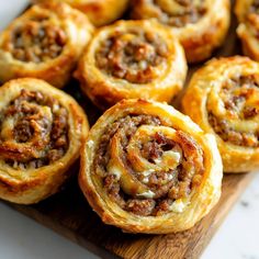 there are many different types of pastries on the cutting board, including cinnamon rolls