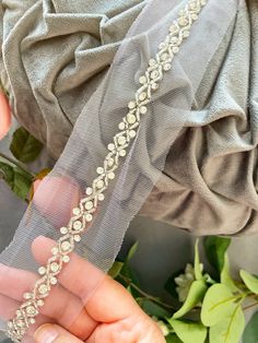 a woman is wearing a veil with flowers on it and holding onto her wedding garter