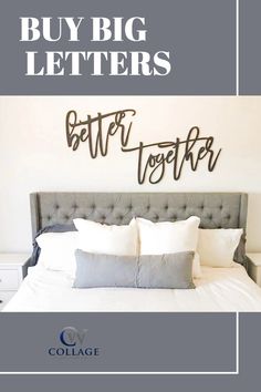 a bed with white sheets and pillows under a metal sign that says, buy big letters better together