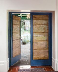 an open door with bamboo blinds on the outside and inside, leading to a patio