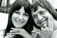 a man and woman are smiling for the camera while holding their hands on each other's shoulders