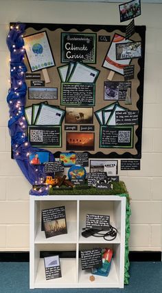 a bulletin board with writing and pictures on it in front of a blue carpeted wall