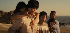 a group of people standing next to each other near the ocean