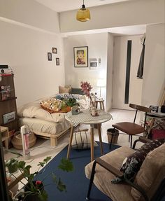 a living room filled with furniture next to a blue carpeted floor and white walls