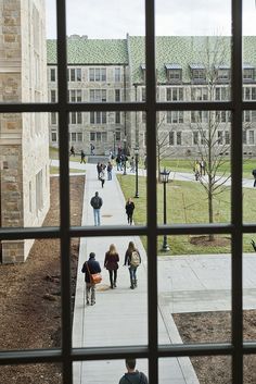 several people walking down a walkway in front of a building