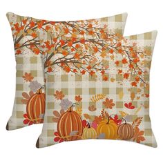 two decorative pillows with pumpkins and leaves on them