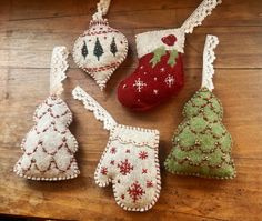 four christmas ornaments hanging on a wooden table