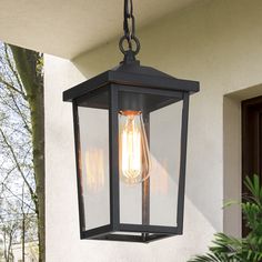 an outdoor light hanging from the side of a house