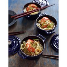 three bowls filled with shrimp and noodles on top of a wooden table next to chopsticks