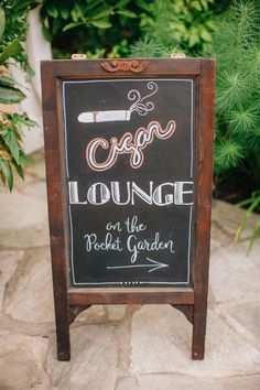 a chalkboard sign that says escape lounge on the rock garden