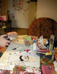 a woman sitting at a table holding a cell phone