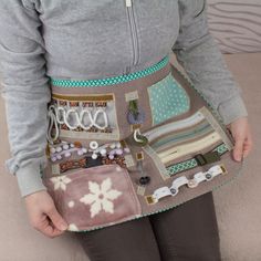 a woman is holding a purse made out of fabric and other things in her hands