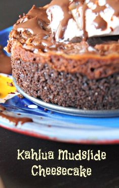 a chocolate cheesecake on a blue plate with the words kahlua mudside cheesecake