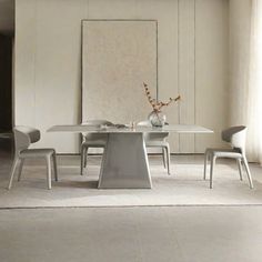 a dining room table with chairs and a vase on it