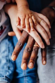 two people holding each other's hands while sitting on the ground with their fingers together