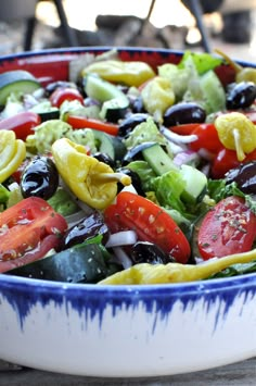 a colorful salad is in a blue and white bowl