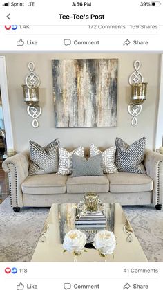 a living room filled with furniture and pillows on top of a table in front of a painting