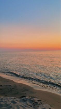 the sun is setting over the water at the beach