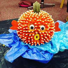 an orange and yellow paper mache with eyes on it