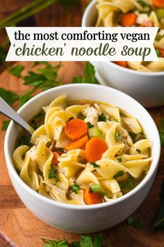 two white bowls filled with chicken noodle soup on top of a wooden cutting board