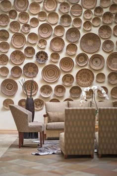 a living room filled with furniture next to a wall covered in plates on the wall