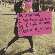 a woman holding a sign that says as a woman, i just hope that one day i have, as many rights as a gon does