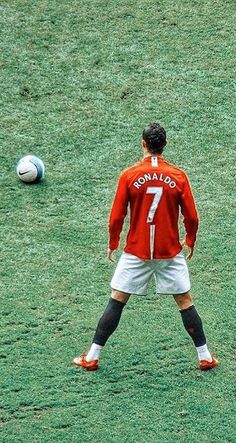 two soccer players in red and white uniforms are on the field playing with a ball