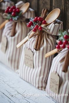 wooden spoons are wrapped in burlocks with red berries and cinnamon sticks on them