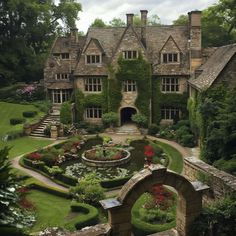 an aerial view of a large house surrounded by greenery and flowers in the front yard