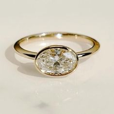 a close up of a ring with a diamond on the bottom and an oval shape