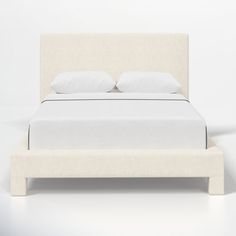 a bed with white linens and pillows on it's headboard is shown