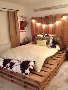 a bed made out of pallets with lights on the headboard and foot board