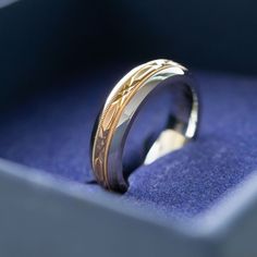 a close up of a wedding ring on a blue velvet box with the lid open