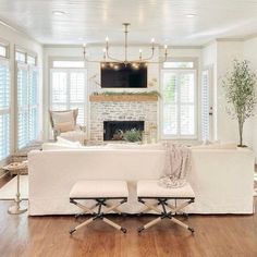 a living room filled with furniture and a flat screen tv mounted to the wall above a fireplace