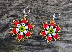 two colorful beaded earrings sitting on top of a wooden table