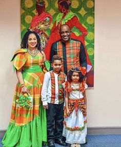 a man and two children standing next to each other in front of a colorful painting